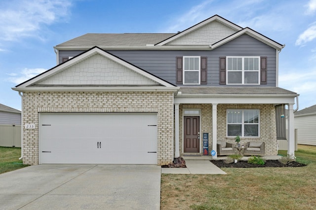 view of front facade with covered porch, a garage, and a front lawn