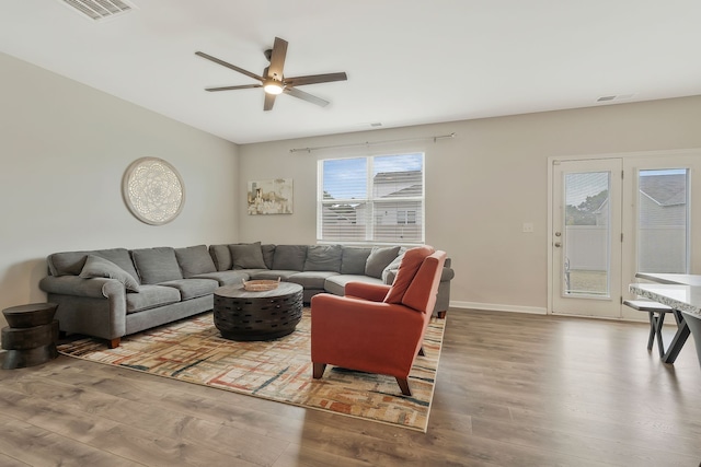 living room featuring wood-type flooring and ceiling fan