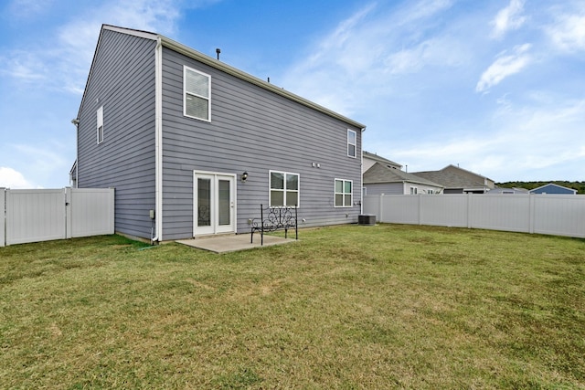 back of house featuring a lawn and a patio area