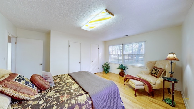 bedroom with wood-type flooring and a textured ceiling