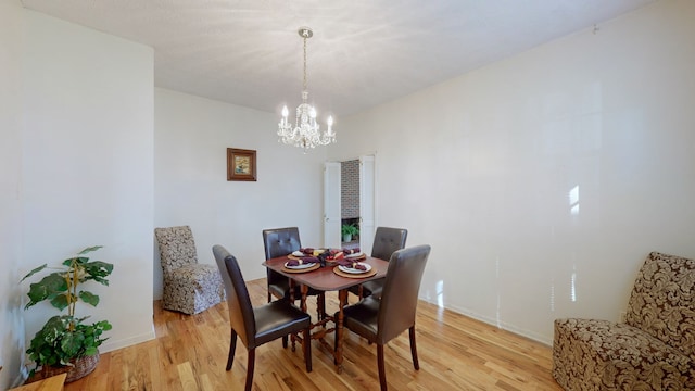 dining space with a chandelier and light hardwood / wood-style floors