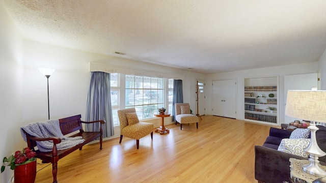 sitting room featuring a textured ceiling and light hardwood / wood-style flooring