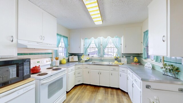 400 Edgewood Dr, Tullahoma, TN 37388 - kitchen with white appliances, under cabinet range hood, light countertops, a sink, and a textured ceiling