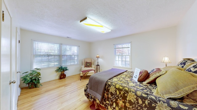 bedroom featuring a textured ceiling and light wood-type flooring