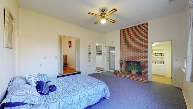 carpeted bedroom featuring ceiling fan, a fireplace, a textured ceiling, and ornamental molding