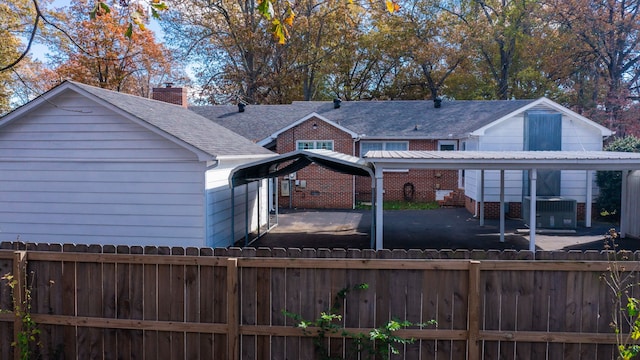 back of house with a patio area, cooling unit, and a carport