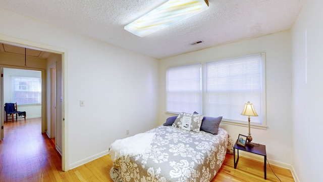 bedroom with hardwood / wood-style floors and a textured ceiling