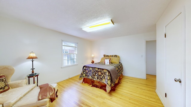 bedroom with hardwood / wood-style flooring and a textured ceiling