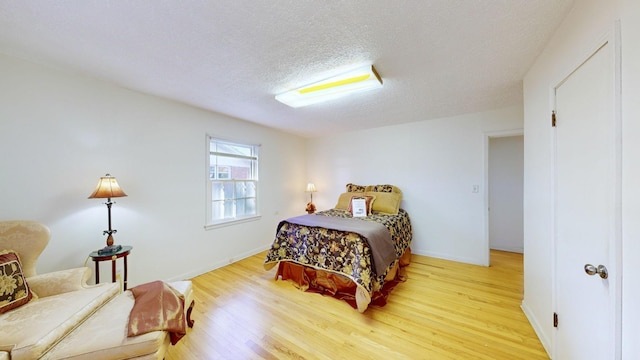 400 Edgewood Dr, Tullahoma, TN 37388 - bedroom featuring light wood-type flooring, a textured ceiling, and baseboards