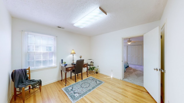 office area featuring ceiling fan, hardwood / wood-style floors, and a textured ceiling