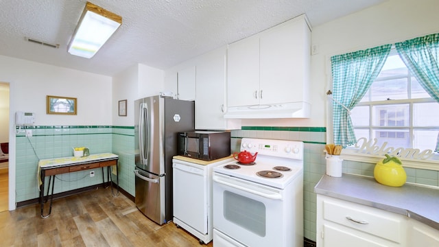 kitchen with white cabinets, white appliances, tile walls, and light hardwood / wood-style flooring