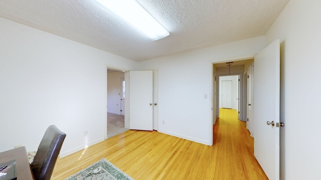 unfurnished office with a textured ceiling and hardwood / wood-style flooring