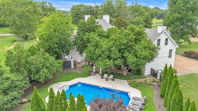 pool with a yard and a patio area