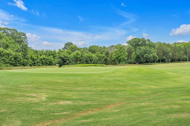 view of community featuring view of golf course and a lawn