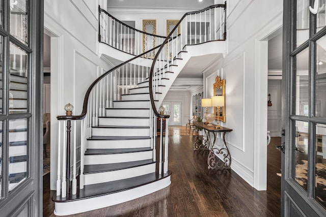 entrance foyer featuring a high ceiling, crown molding, and dark wood-type flooring