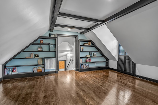 additional living space featuring lofted ceiling, hardwood / wood-style floors, and built in shelves