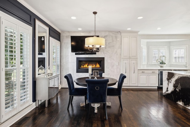 dining area with visible vents, a large fireplace, dark wood-style flooring, and crown molding