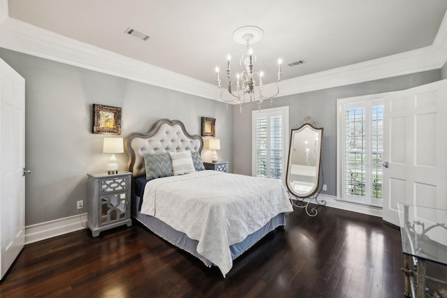 bedroom with visible vents, ornamental molding, hardwood / wood-style floors, an inviting chandelier, and baseboards