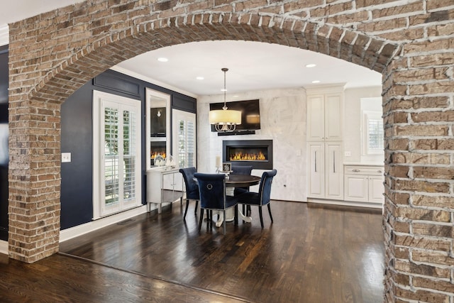 dining space featuring arched walkways, dark wood-style floors, recessed lighting, and visible vents