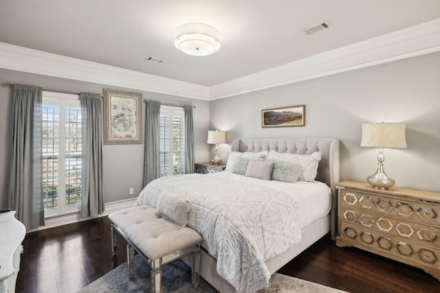 bedroom featuring dark wood-style floors, visible vents, and crown molding