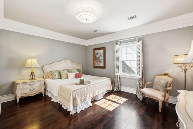 bedroom with visible vents, crown molding, baseboards, and hardwood / wood-style floors