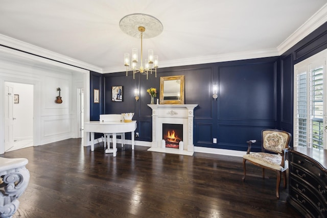 interior space with a notable chandelier, wood finished floors, crown molding, and a decorative wall