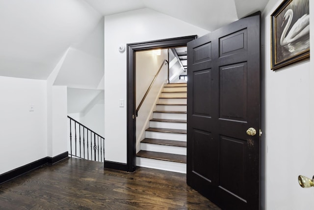 staircase with baseboards, lofted ceiling, and wood finished floors