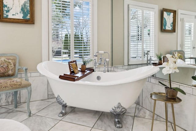 full bathroom featuring a healthy amount of sunlight and a freestanding bath