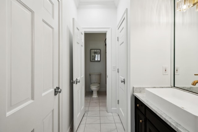 bathroom with crown molding, baseboards, toilet, marble finish floor, and vanity