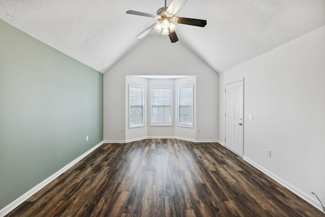 spare room featuring a textured ceiling, vaulted ceiling, ceiling fan, and dark wood-type flooring