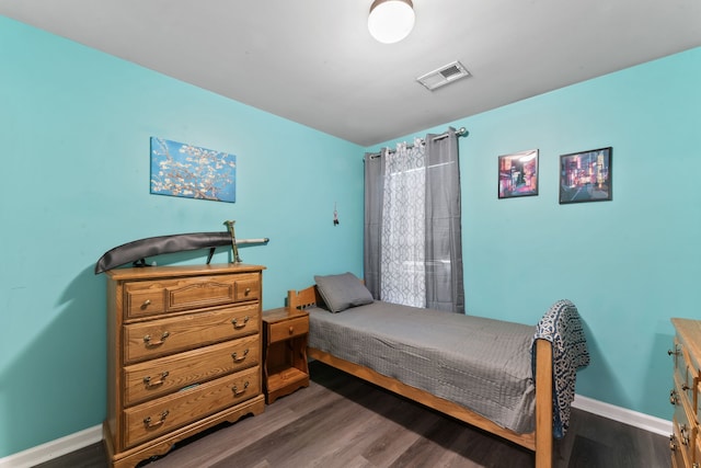 bedroom with dark hardwood / wood-style flooring