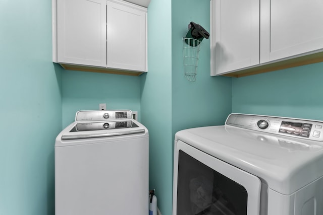 washroom featuring cabinets and separate washer and dryer