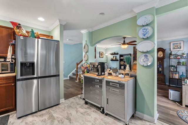 kitchen featuring crown molding, ceiling fan, stainless steel fridge, light wood-type flooring, and butcher block countertops