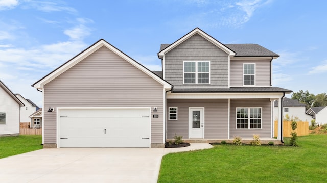 view of front of home with a front yard, a garage, and covered porch