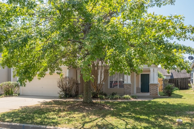 view of property hidden behind natural elements with a front yard and a garage