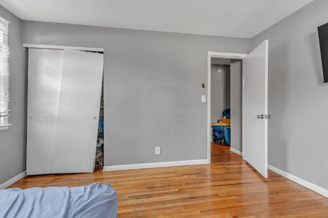 bedroom with light hardwood / wood-style flooring and a closet