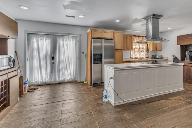 kitchen featuring island exhaust hood, sink, dark hardwood / wood-style floors, and appliances with stainless steel finishes