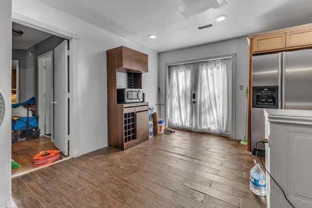 kitchen featuring dark hardwood / wood-style floors, light brown cabinets, and stainless steel appliances