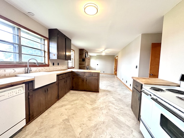 kitchen featuring white appliances, sink, kitchen peninsula, ceiling fan, and dark brown cabinetry