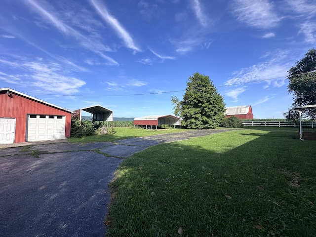 view of yard with an outbuilding, a garage, and a carport