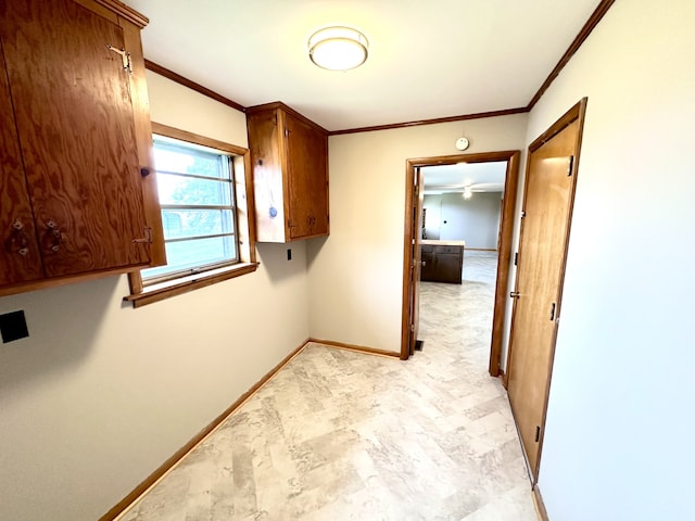 clothes washing area with crown molding, ceiling fan, and cabinets