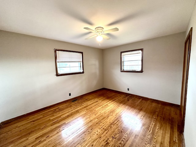 empty room with hardwood / wood-style floors and ceiling fan