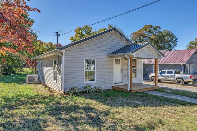 bungalow-style house featuring ac unit and a front lawn