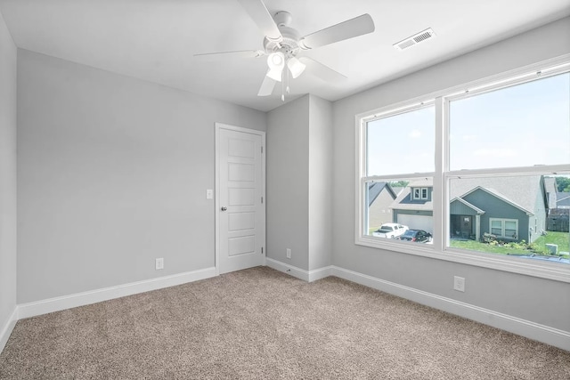 carpeted spare room with ceiling fan