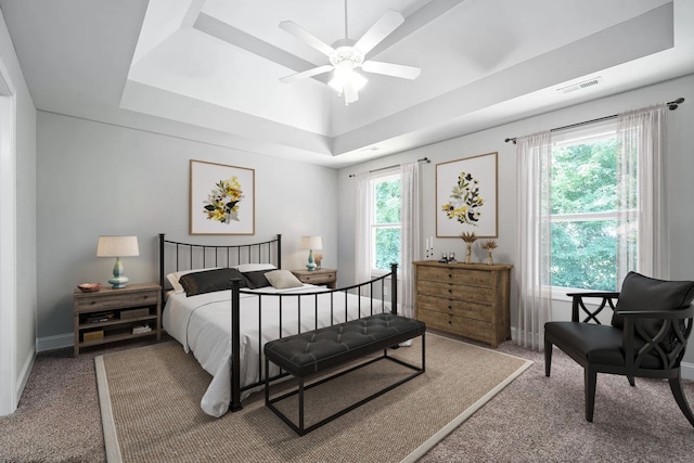 bedroom featuring carpet, a tray ceiling, and ceiling fan