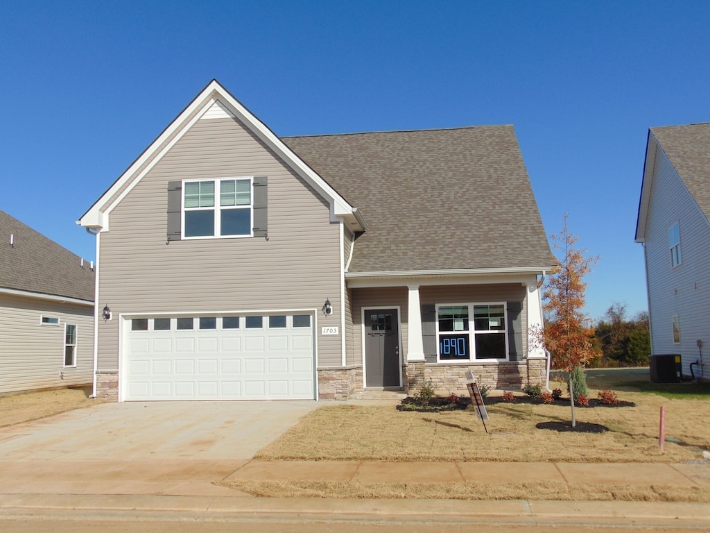 view of front facade featuring central AC unit and a garage