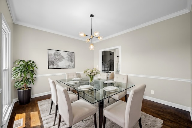 dining space featuring a chandelier, dark hardwood / wood-style floors, and crown molding