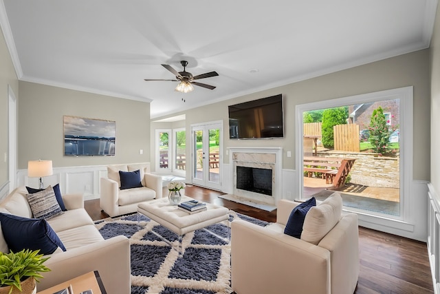 living room featuring a fireplace, a wealth of natural light, and crown molding