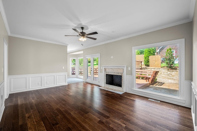 unfurnished living room with dark hardwood / wood-style flooring, ceiling fan, crown molding, and a premium fireplace