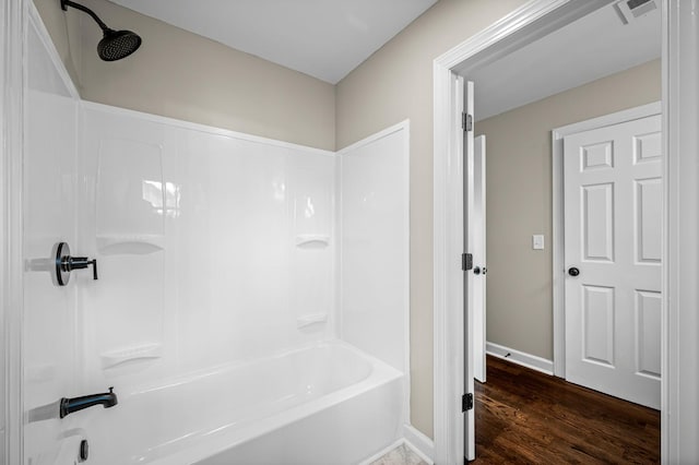 bathroom with hardwood / wood-style floors and  shower combination